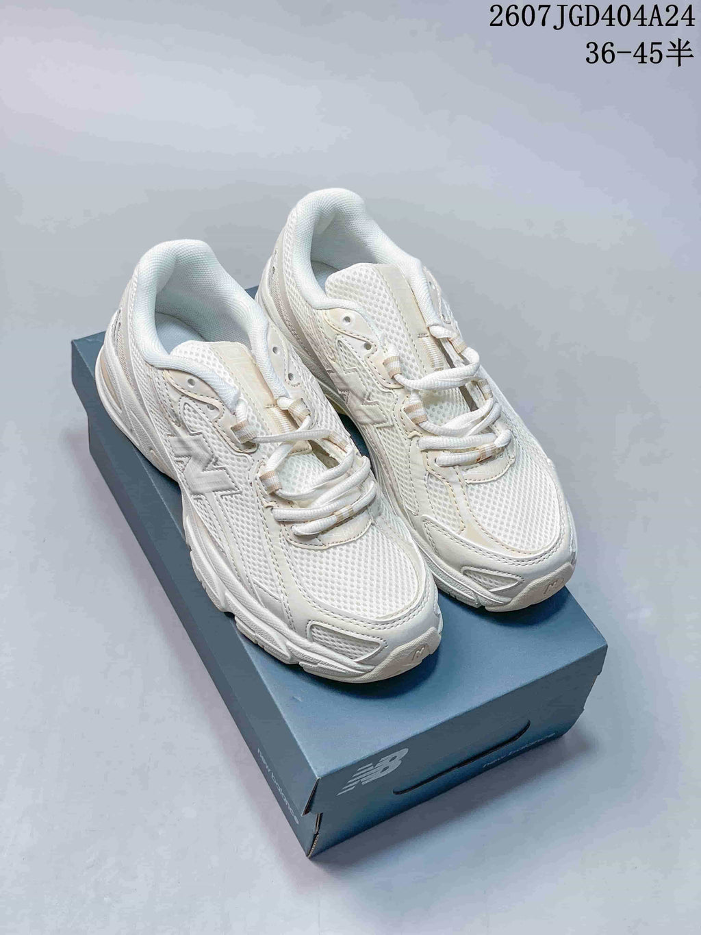 Pair of beige New Balance 740 sneakers displayed on a New Balance shoebox.
