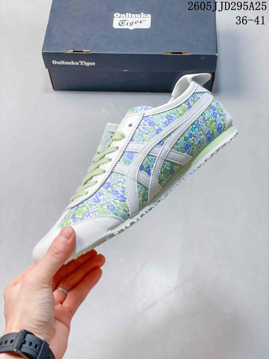 Side view of the white sneaker with green and blue floral panels, pale green midsole detail, and contrasting stripes.