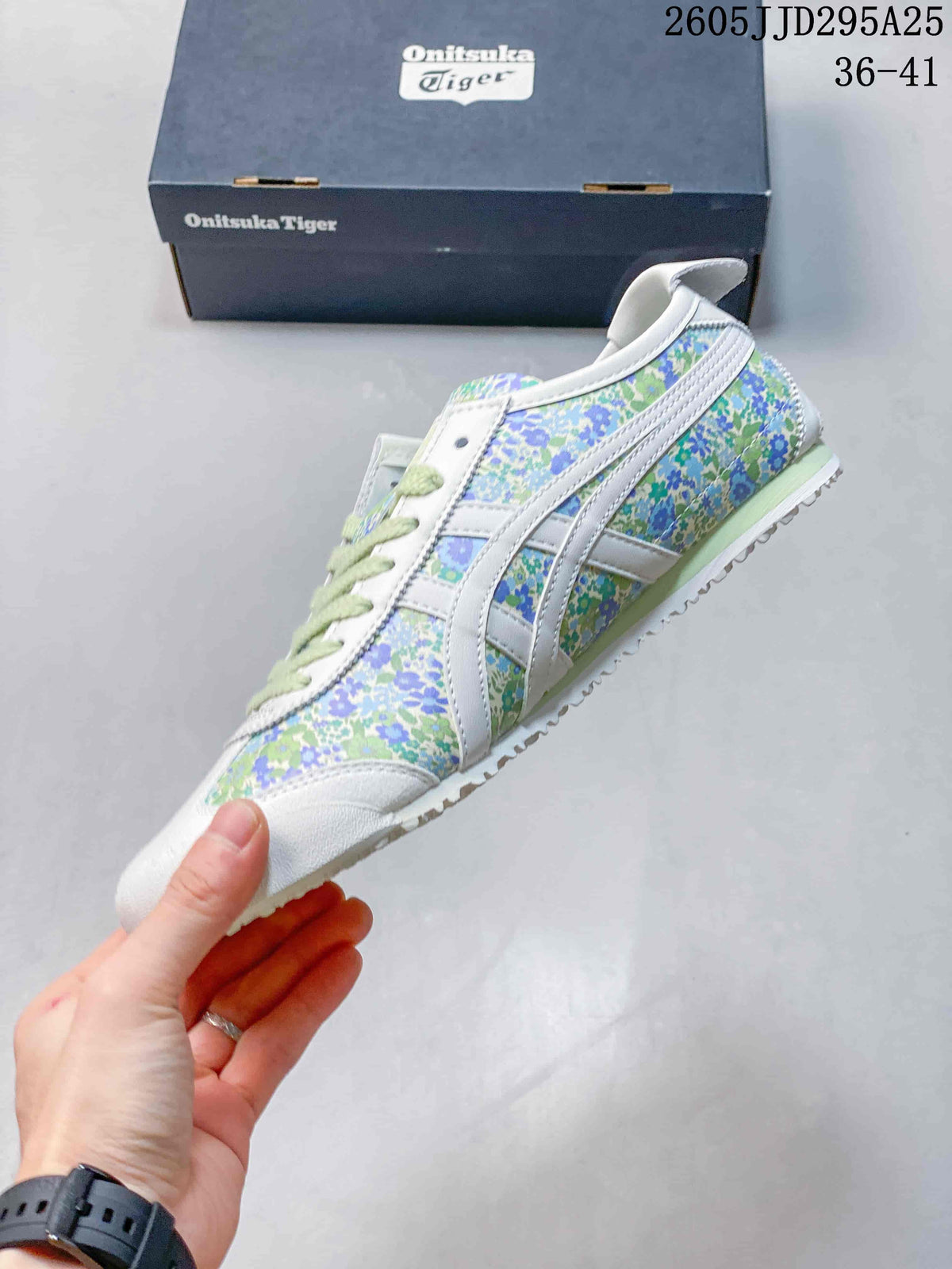 Side view of the white sneaker with green and blue floral panels, pale green midsole detail, and contrasting stripes.