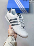 Angled side view showing the white upper, dark three stripes, lace-up front, and heel detail.