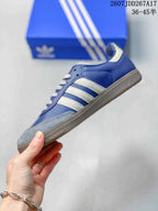 Side profile showing the blue upper, white three-stripe details, gray toe panel, and low-top silhouette.