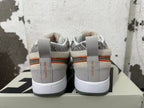 Rear view of gray, off-white, and orange Nike Book 1 sneakers showing patterned collars and heel details.