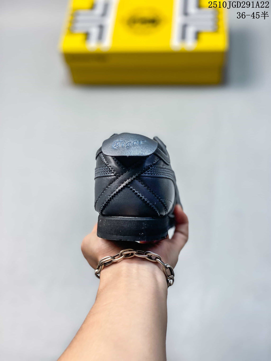 Rear view of the black sneaker showing the heel panel, stitched overlays, and outsole.