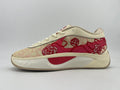 Side view of cream and red low-top sneakers with rose-patterned panels and a sculpted sole