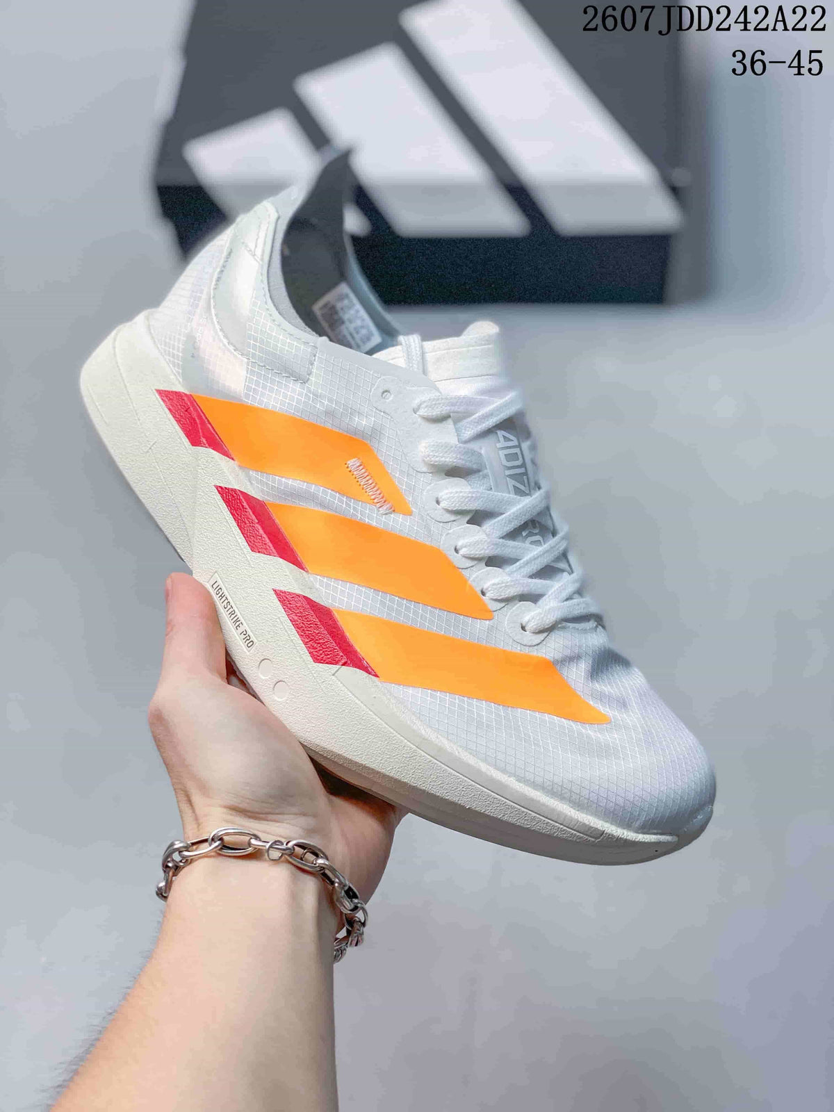 White Y-3 Adios Pro 4 sneaker with orange side overlays and red accents; image text shows JDD242A22 and sizes 36–45.