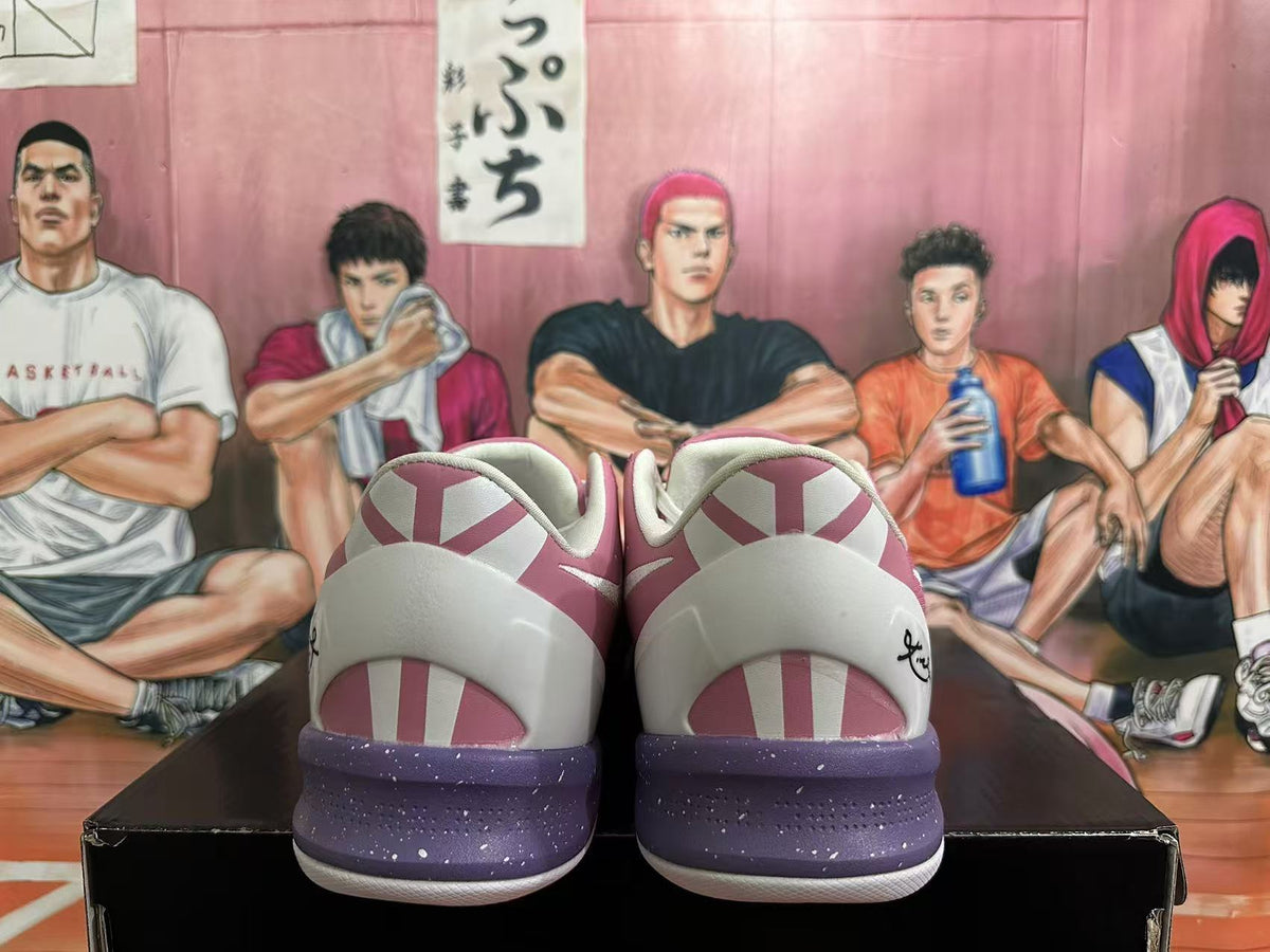 Rear view of pink and white basketball shoes with purple-speckled midsoles and geometric heel details.