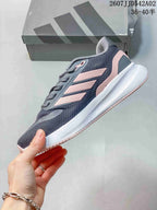 Side view showing the gray upper, pink accents, and white midsole.