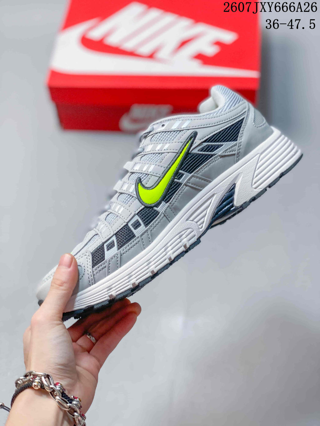 Side profile of the grey and volt low-top sneaker showing layered panels, mesh-like sections, and a contrasting Swoosh.
