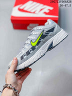 Side profile of the grey and volt low-top sneaker showing layered panels, mesh-like sections, and a contrasting Swoosh.