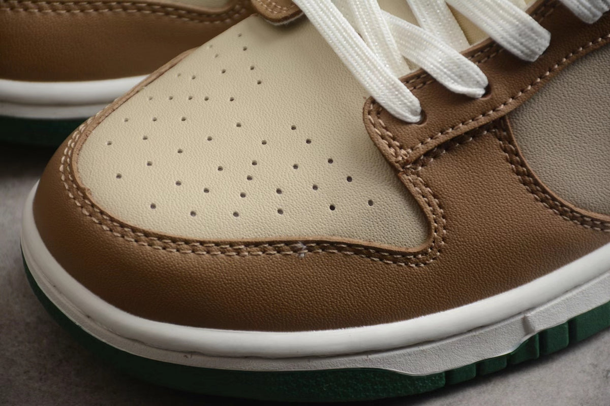 Close-up of the perforated cream toe panel, brown overlays, white midsole, and green outsole.