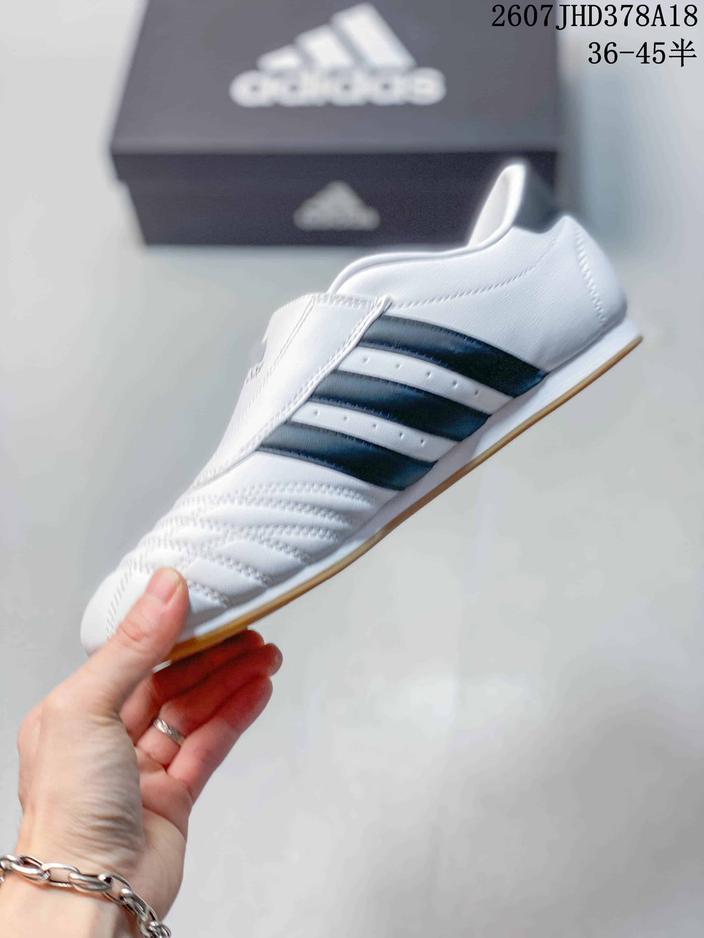 Side profile of the white low-top sneaker with three dark navy stripes, stitched panels and a gum-colored outsole.