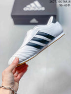 Side profile of the white low-top sneaker with three dark navy stripes, stitched panels and a gum-colored outsole.