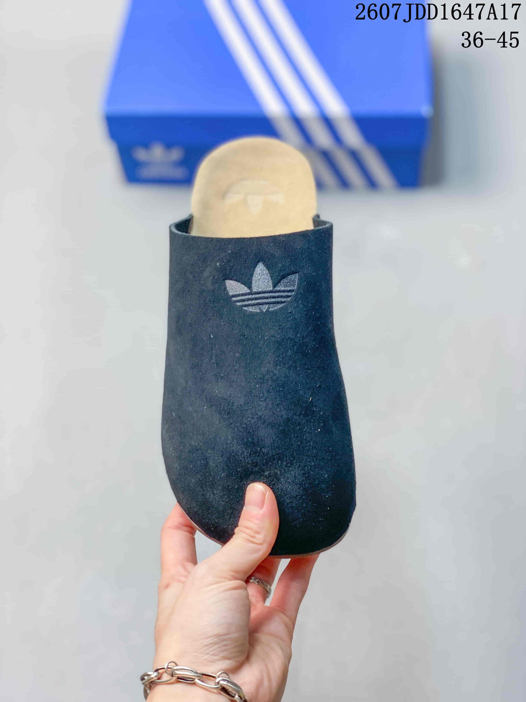 Front view of a black adidas slide with a covered rounded toe and Trefoil logo on the upper.