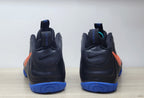 Rear view of the black Nike Air Foamposite Pro pair with blue outsole sections and orange side accents.
