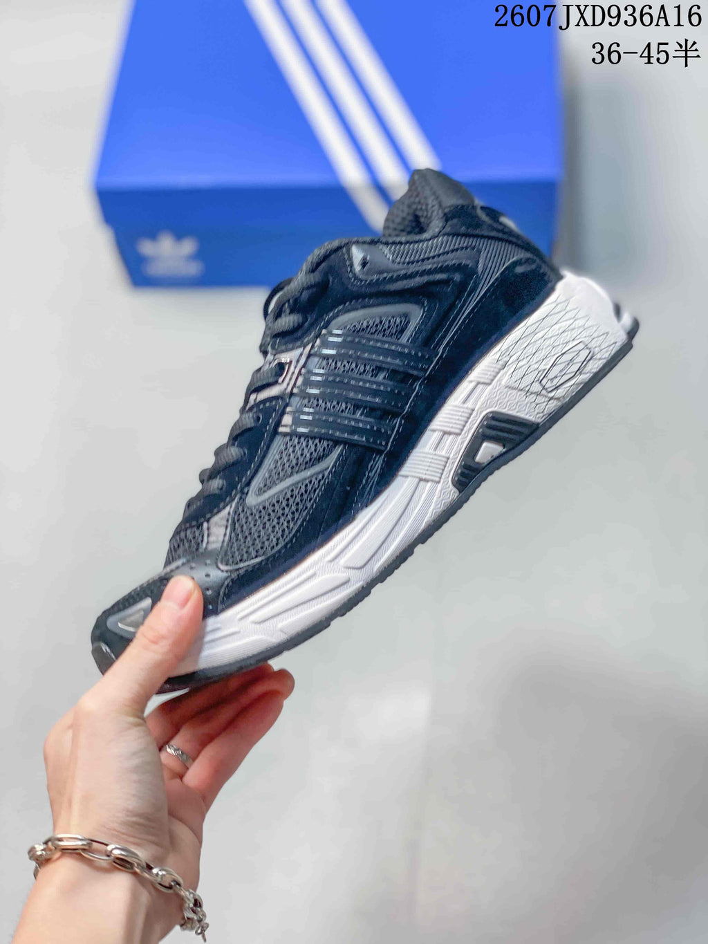 Side view highlighting the layered dark upper, mesh panels and white midsole.
