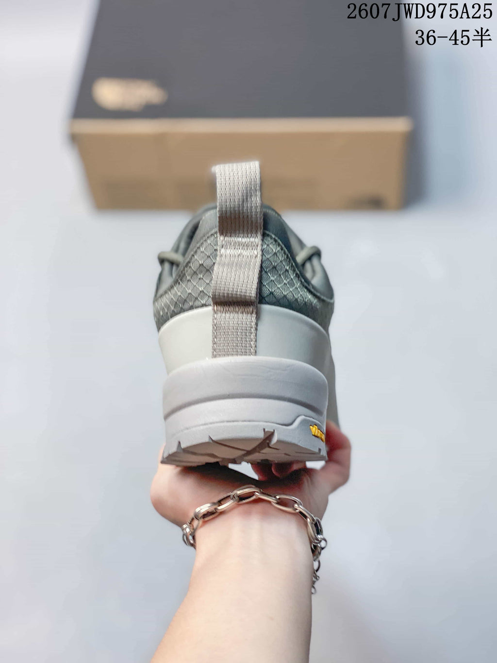 Rear view of the gray sneaker showing the heel pull tab, padded collar and textured upper.