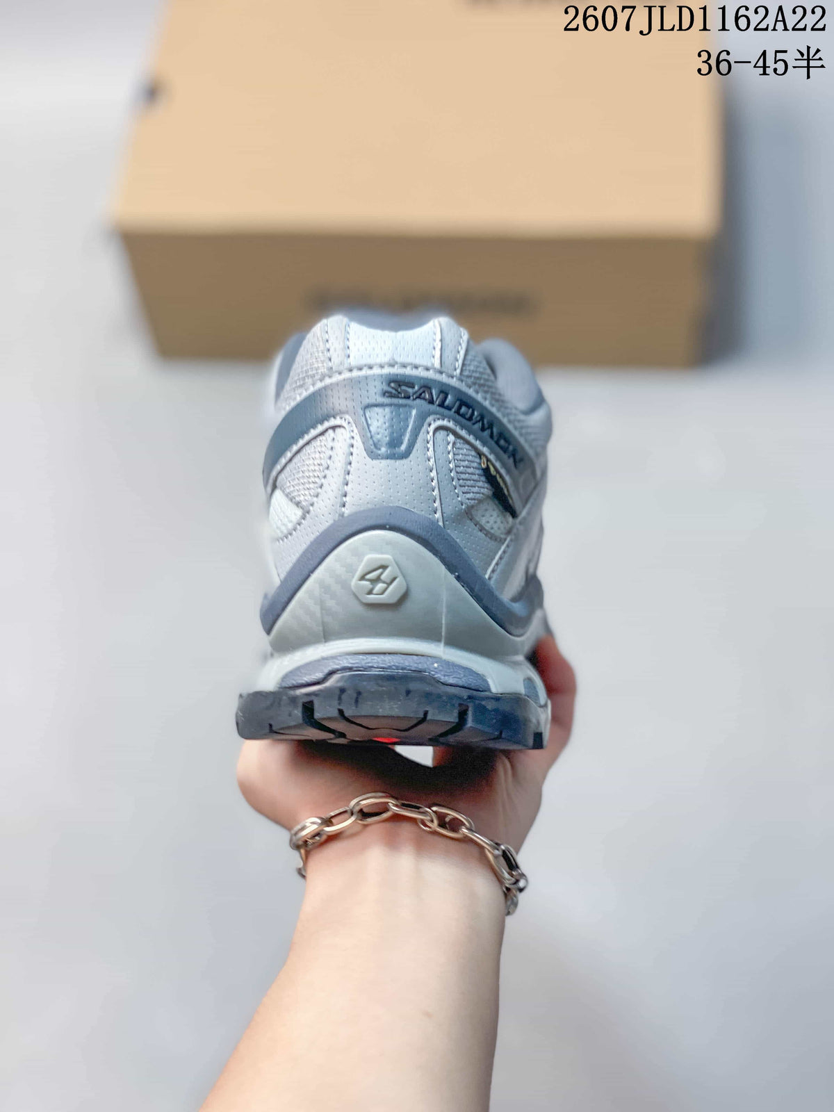 Rear view of the grey and silver sneaker showing the padded heel collar and Salomon branding.
