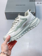 Side view of the white and pale sage sneaker with layered panels and a thick treaded sole.