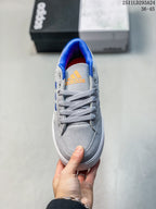Top view of the grey lace-up sneaker with orange tongue branding and blue collar lining.