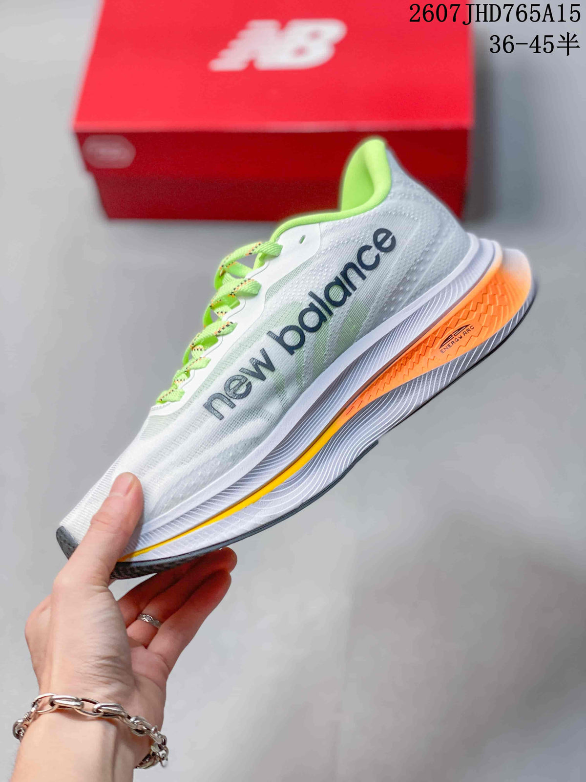 Side profile of the white New Balance running shoe with lime-green details and an orange outsole section.