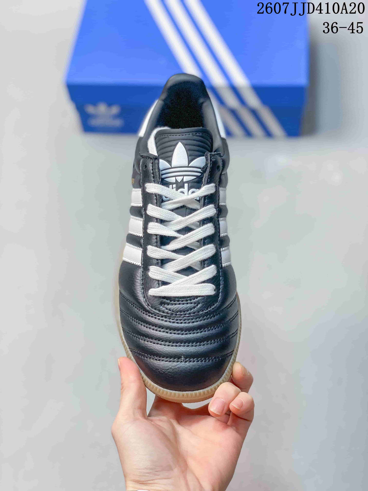 Top view showing the black toe area, white laces, and trefoil tongue logo.