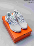 Pair of light gray and white Nike Vomero 18 running shoes with blue accents displayed on an orange shoebox; text shows style code 2607JHY971A21 and size range 36–40.5.