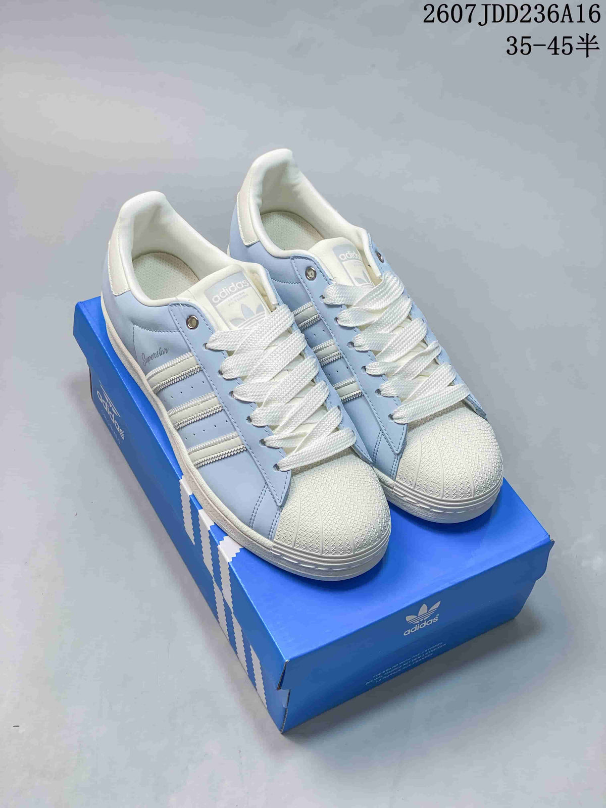 Pair of light blue and white adidas Superstar sneakers displayed on a blue shoebox; image text shows style code 2607JDD236A16 and size range 35–45.