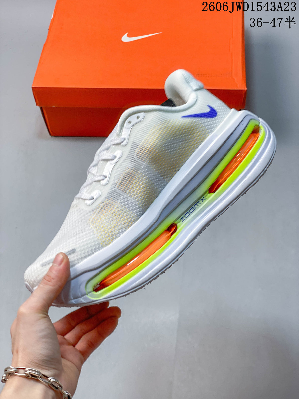 Side view of the white Nike running shoe with a purple Swoosh and bright lime and orange midsole details.