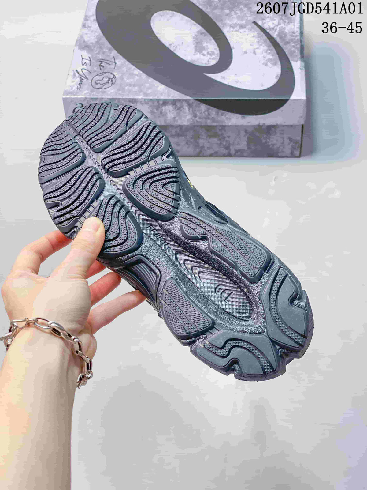 Close-up of the patterned outsole on a yellow and charcoal sneaker