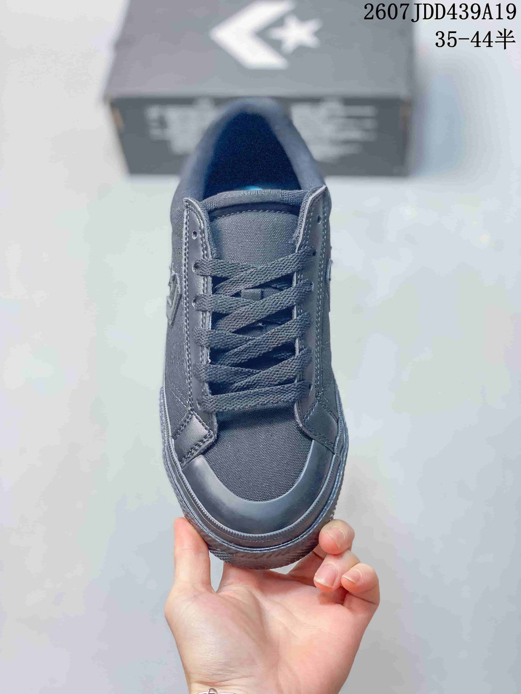 Top view of a black Converse low-top sneaker showing the lace-up closure, padded tongue, and rubber toe cap.