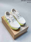 White On Cloudmonster 3 shoes with lime-green soles, shown on a box
