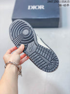 Close view of the dark textured outsole with circular forefoot tread and raised Nike branding; Dior-branded box in the background.