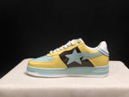 Side profile of a BAPE STA sneaker showing the yellow upper, brown side panel, light blue star detail, and layered sole.