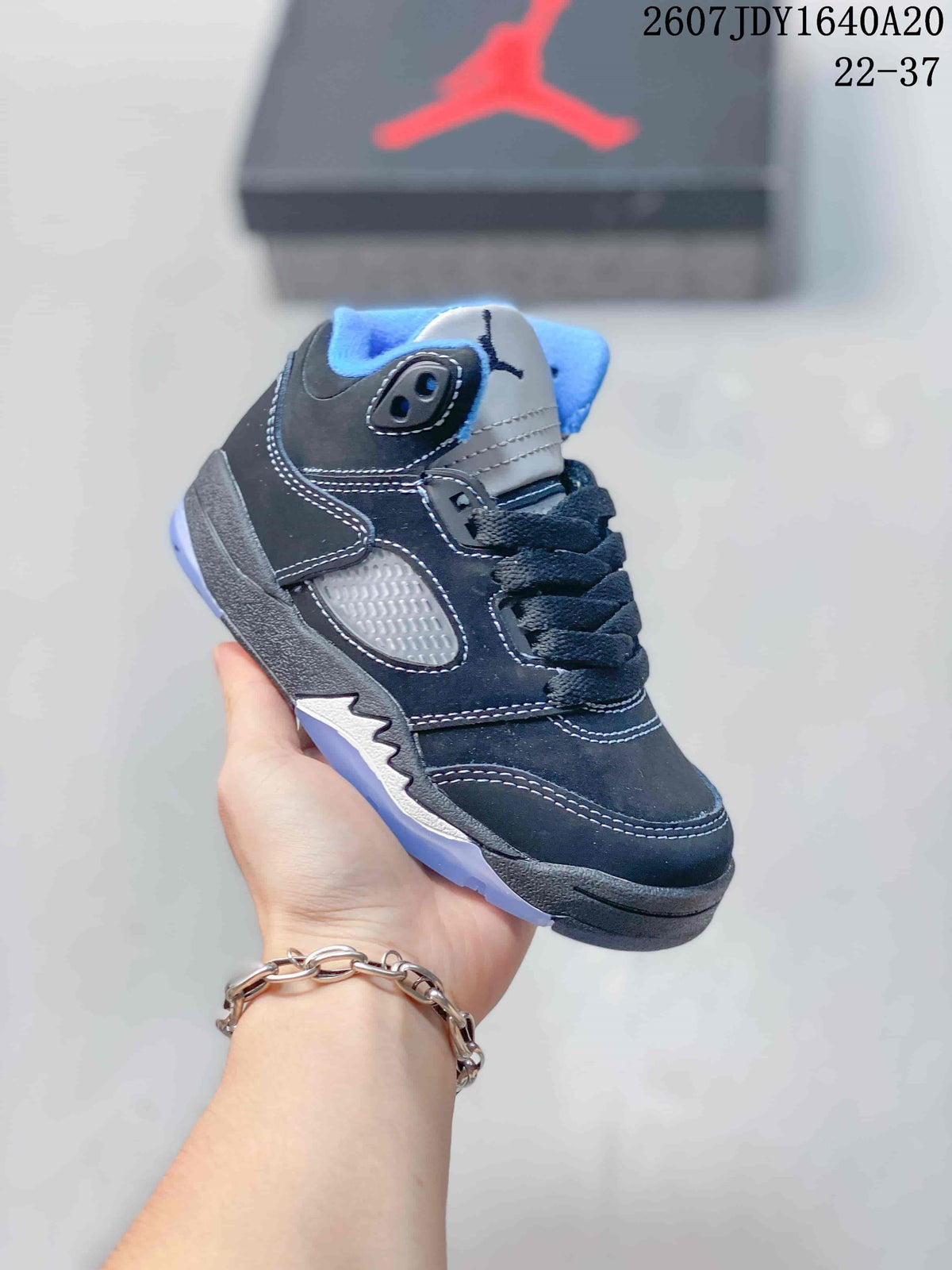 Black and gray kids' mid-top sneaker with blue collar lining and dark laces.
