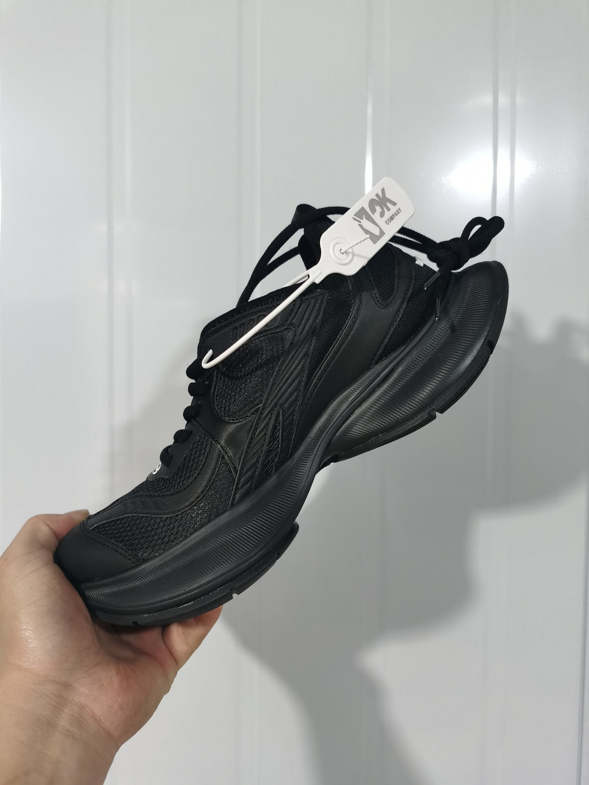 Angled view of a black Balenciaga Circuit sneaker showing the layered upper, tonal laces, textured panels, and sculpted sole.