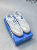 Pair of white and gray Adidas sneakers displayed on a blue shoebox, with SAMBA branding visible on the side.