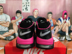 Rear view of black and bright pink Nike basketball sneakers with visible heel cushioning