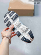 Underside of a running shoe showing segmented dark and white tread