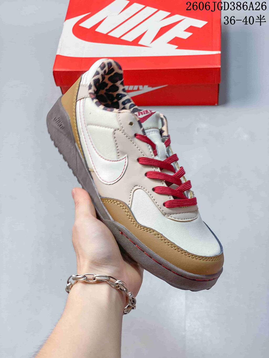 Angled side view showing the cream upper, tan overlays, red laces, gray sole and visible Nike-style side logo.