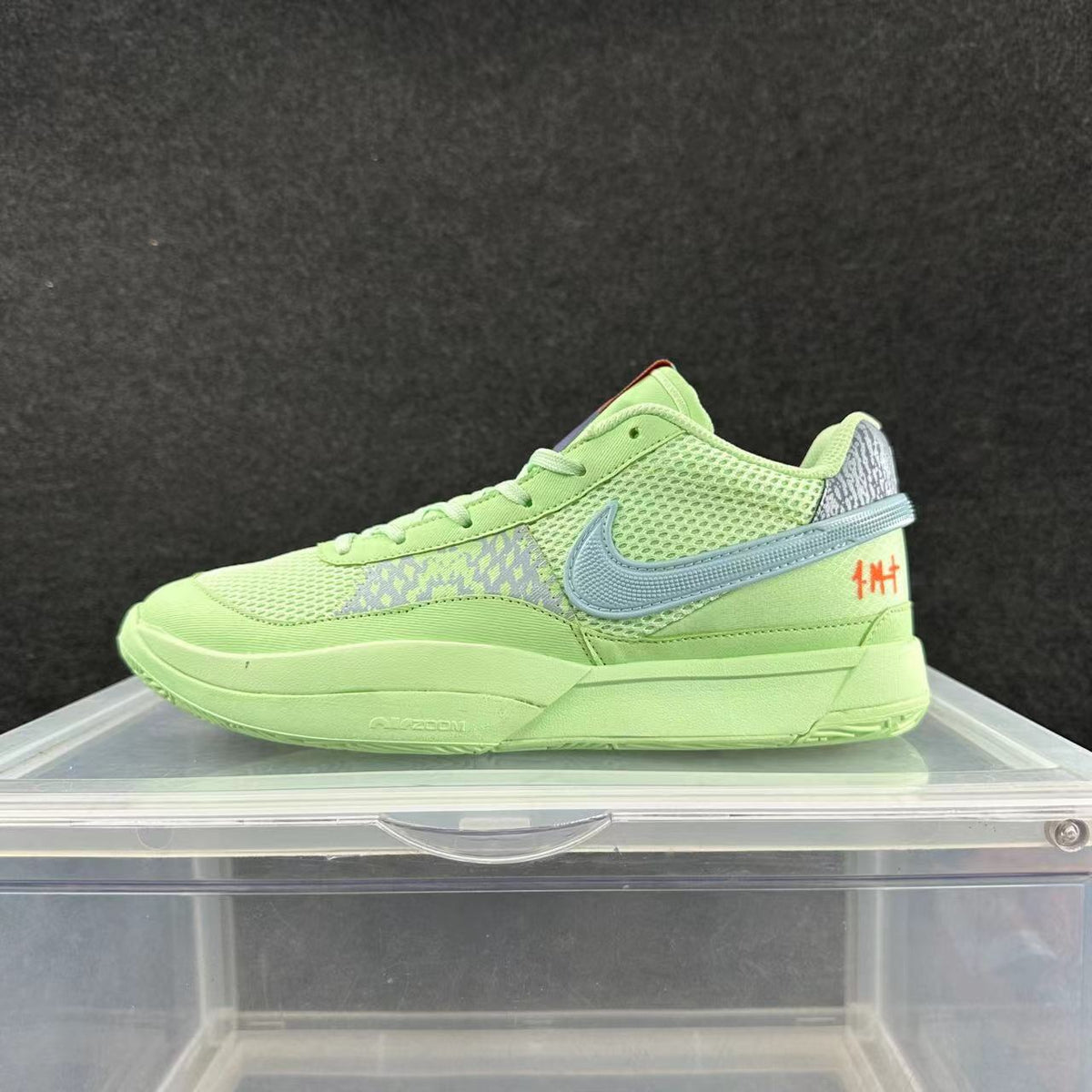 Side view of a lime-green Nike Ja 2 basketball shoe with a blue-gray Swoosh, mesh panels, and orange heel detail.