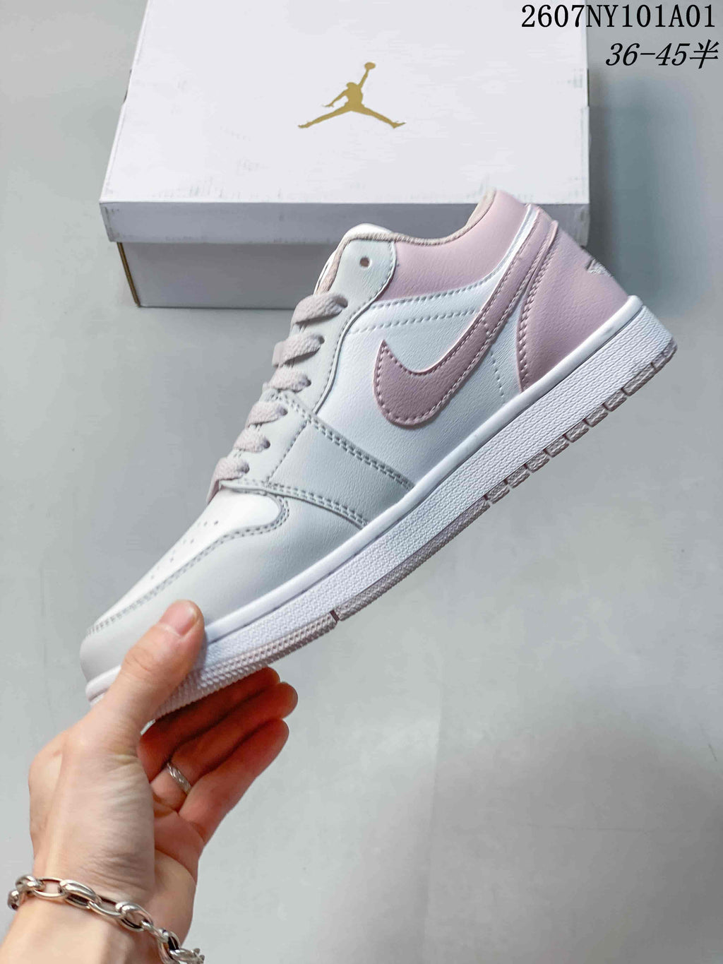 Side view of the low-top sneaker with pale pink accents and a white side panel.