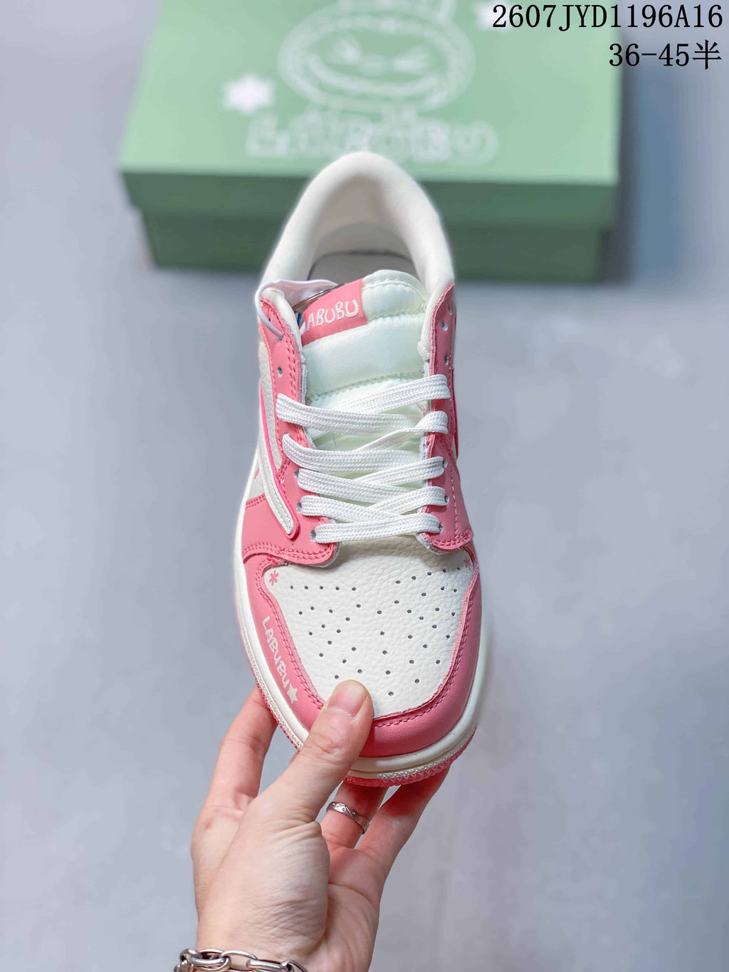 Top view of the sneaker showing white laces, a perforated white toe box, pink overlays, and Labubu lettering.
