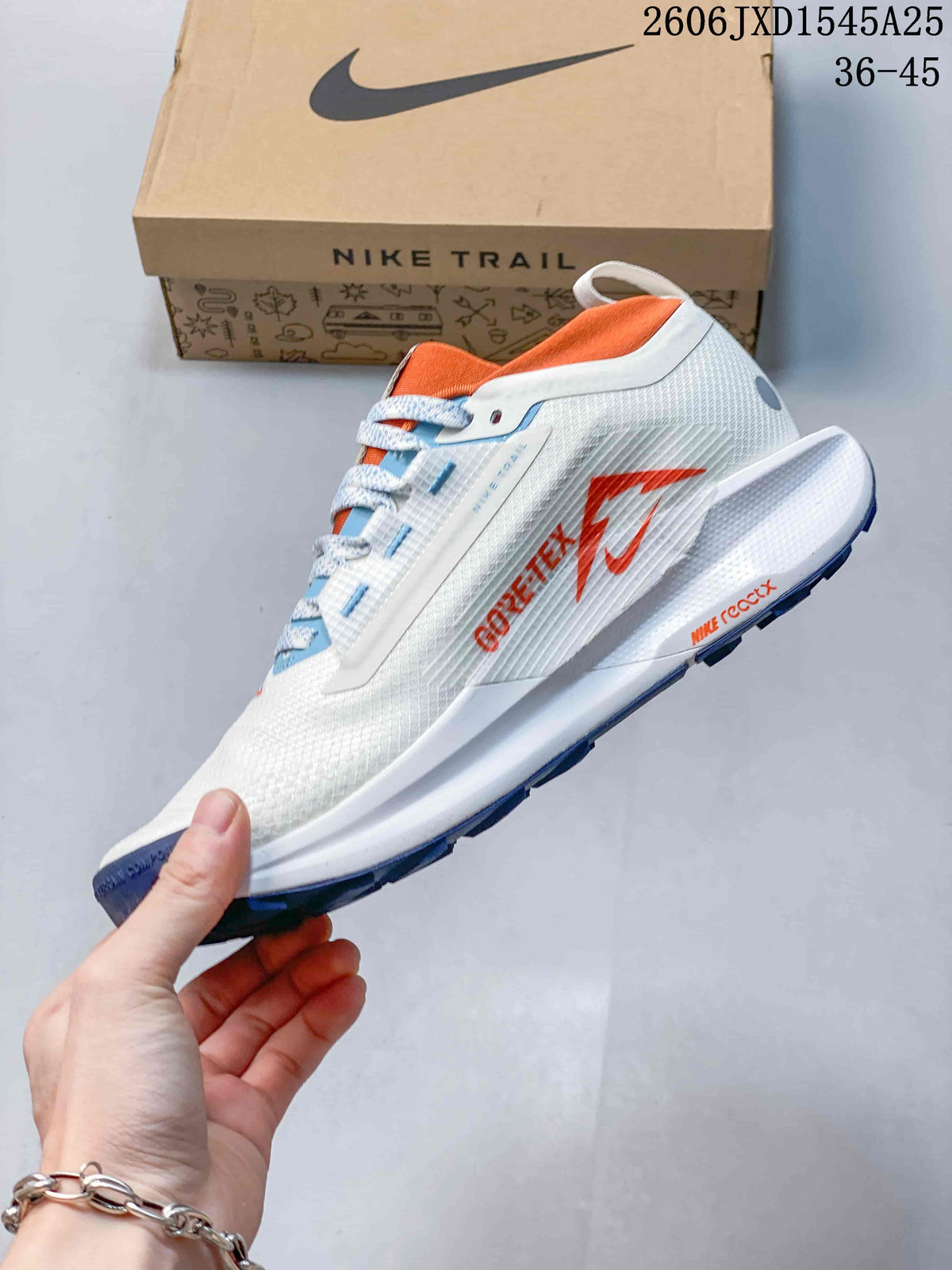 Side view of the white trail shoe with orange accents and visible GTX branding