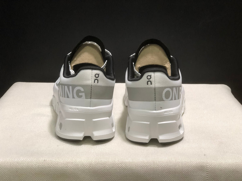 Rear view of the pair showing the On logos, contrasting heel bands, and white heel structure.