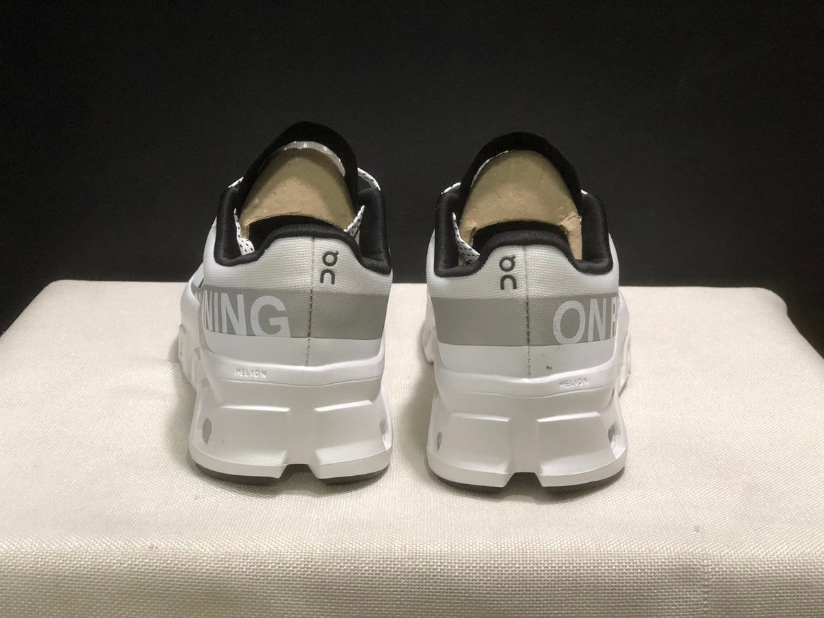 Rear view of the pair showing the On logos, contrasting heel bands, and white heel structure.