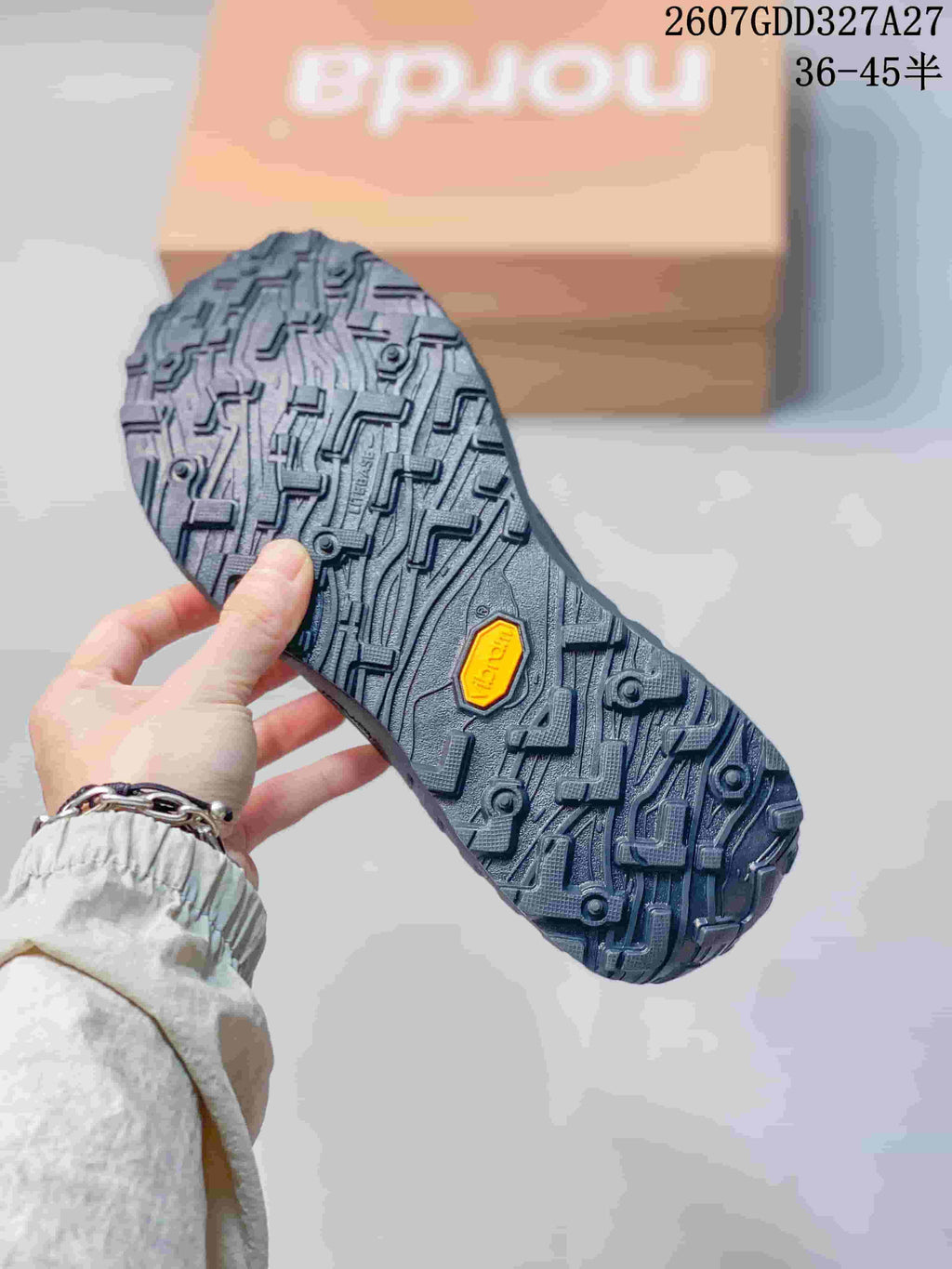 Close view of the rugged outsole with a patterned lug structure and a visible Vibram logo; overlay text shows style code 2607GDD327A27 and sizes 36–45.