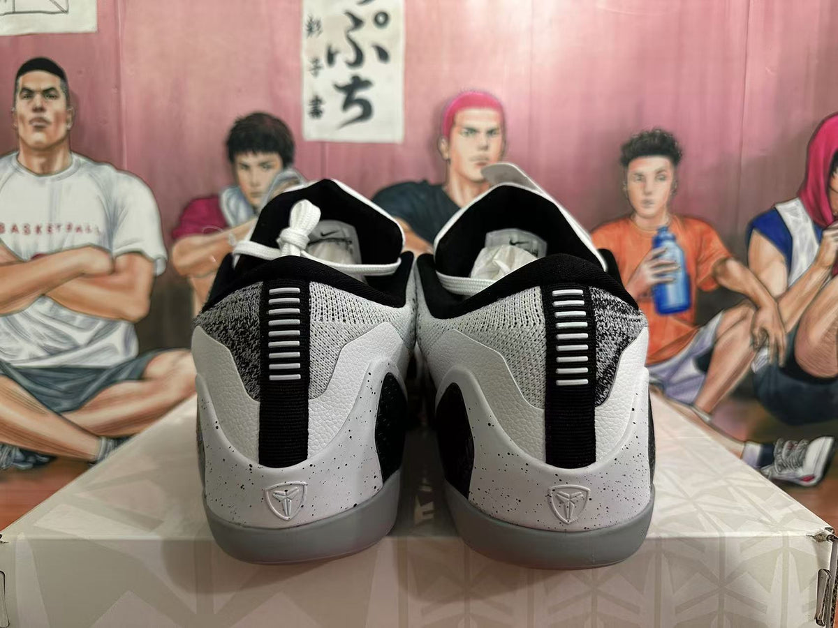 Rear view of black, white and grey basketball sneakers showing padded collars, heel pull tabs and textured heel panels.