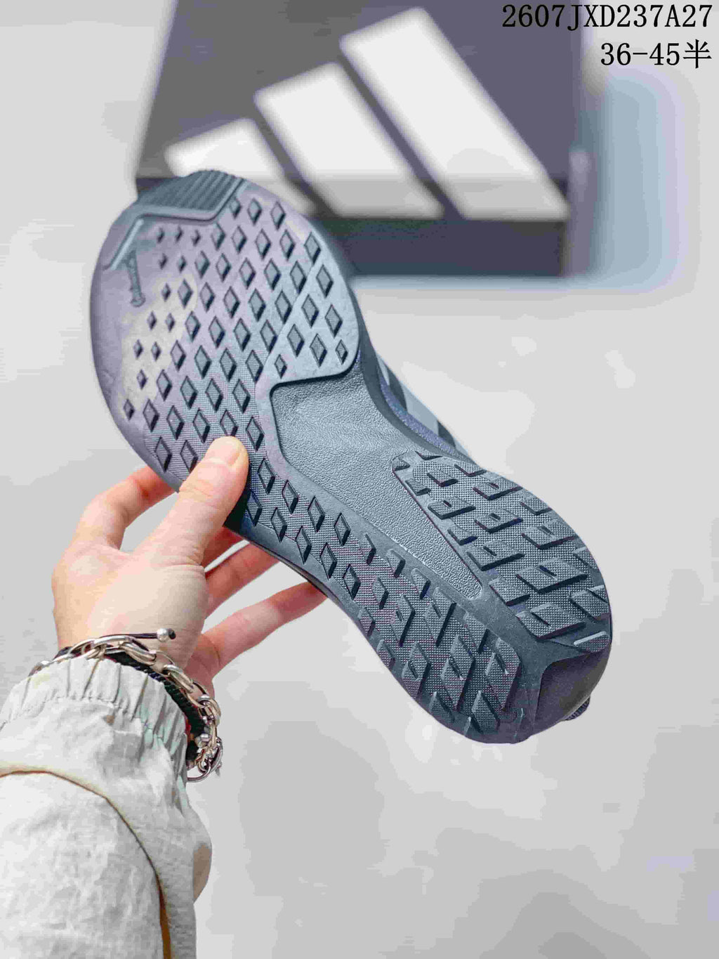Close view of the textured outsole showing geometric tread blocks on a dark gray sneaker.