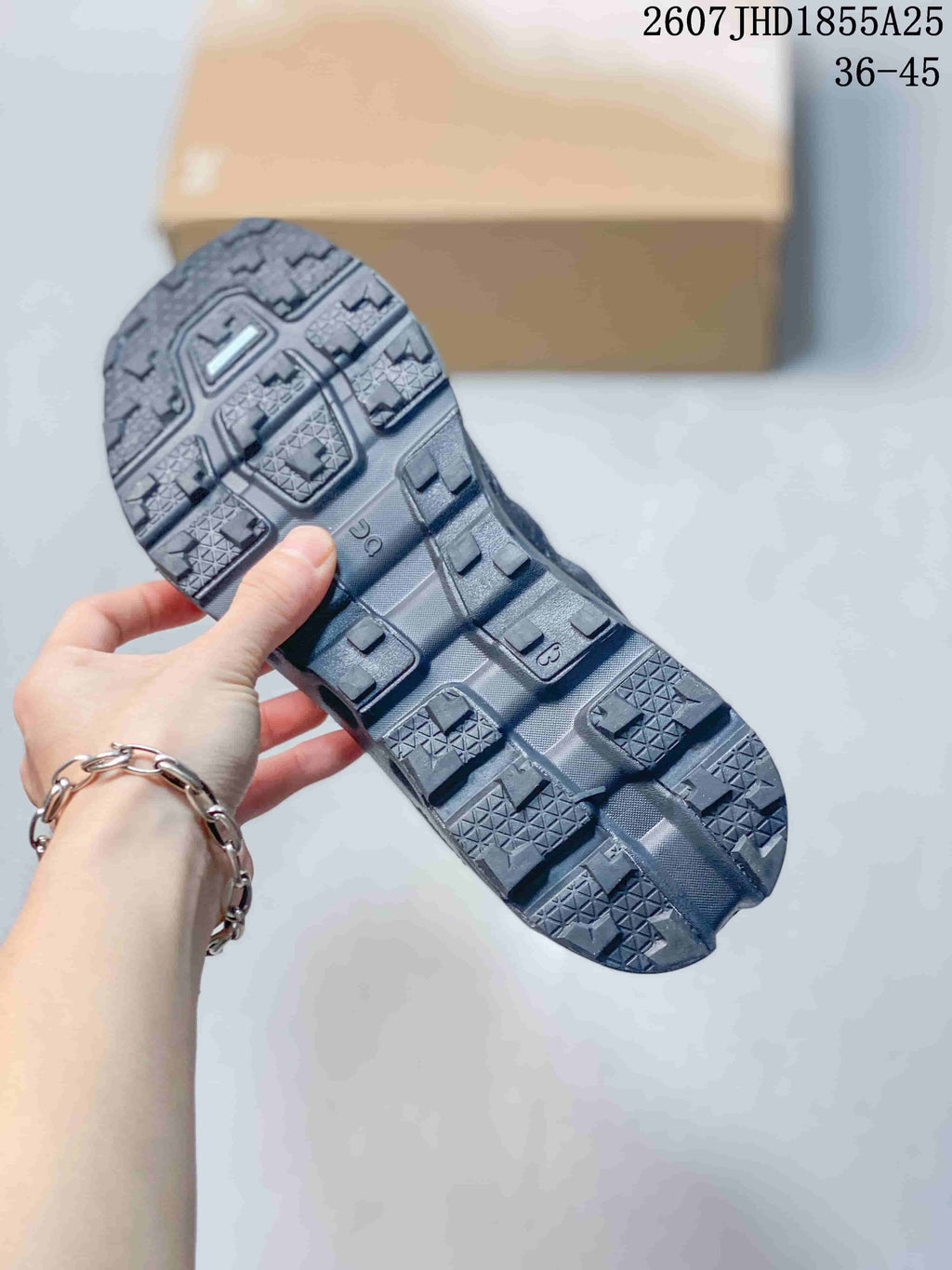 Close-up of the lugged outsole showing square traction blocks, textured tread sections, and open midsole channels.