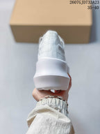 Rear view of the white sneaker showing the raised heel and thick sculpted sole.